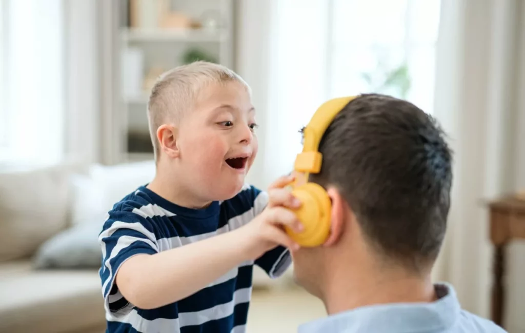 Happy down syndrome boy with father indoors at hom 2024 10 18 13 14 59 utc min