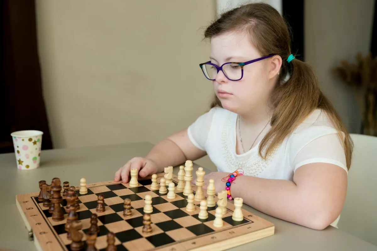 Teenager girl with down syndrome playing chess on 2024 11 27 16 50 06 utc min